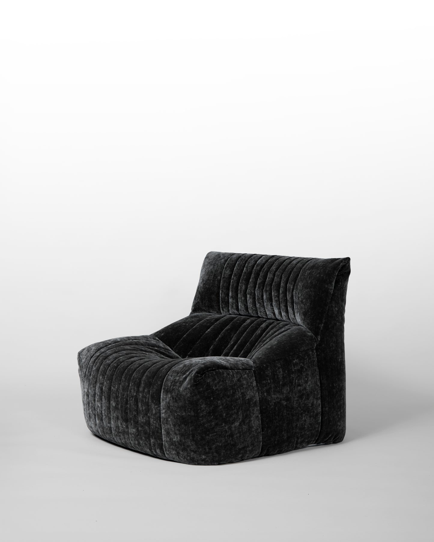 Aralia lounge chair designed by Michel Ducaroy for Ligne Roset in the 1970s, featuring black velvet upholstery, enveloping curves, and a modular design, embodying relaxed elegance and mid-century modern aesthetics.