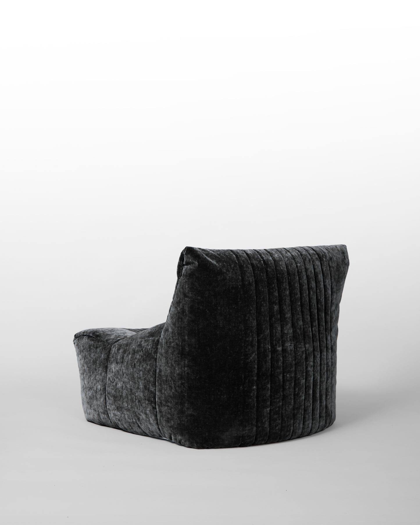 Aralia lounge chair designed by Michel Ducaroy for Ligne Roset in the 1970s, featuring black velvet upholstery, enveloping curves, and a modular design, embodying relaxed elegance and mid-century modern aesthetics.