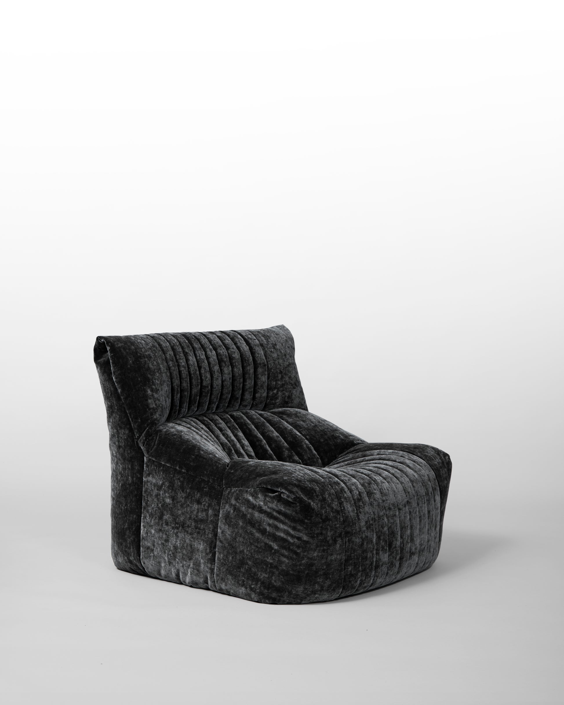 Aralia lounge chair designed by Michel Ducaroy for Ligne Roset in the 1970s, featuring black velvet upholstery, enveloping curves, and a modular design, embodying relaxed elegance and mid-century modern aesthetics.