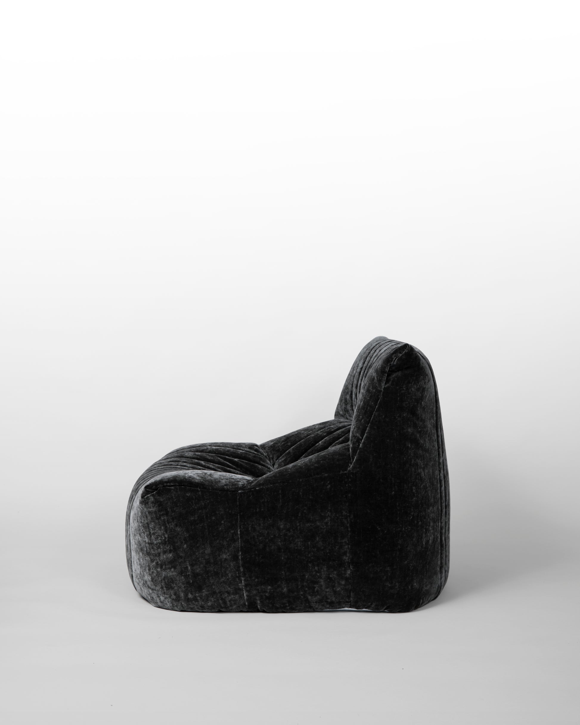 Aralia lounge chair designed by Michel Ducaroy for Ligne Roset in the 1970s, featuring black velvet upholstery, enveloping curves, and a modular design, embodying relaxed elegance and mid-century modern aesthetics.