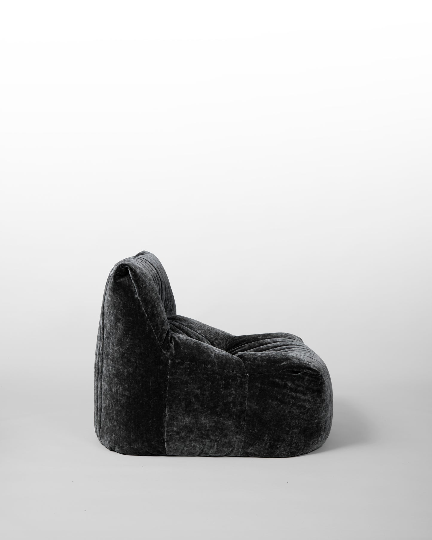 Aralia lounge chair designed by Michel Ducaroy for Ligne Roset in the 1970s, featuring black velvet upholstery, enveloping curves, and a modular design, embodying relaxed elegance and mid-century modern aesthetics.