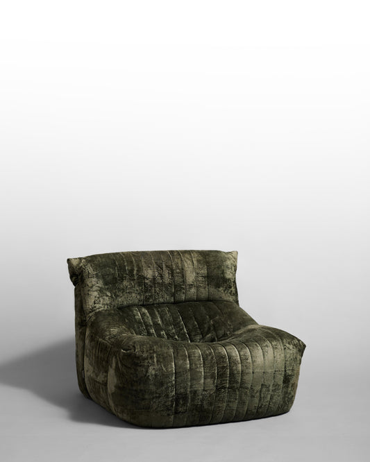 Aralia lounge chair designed by Michel Ducaroy for Ligne Roset in the 1970s, featuring modular design with enveloping curves, textured green upholstery, and quilted details, reflecting the era's focus on organic comfort and relaxed elegance.