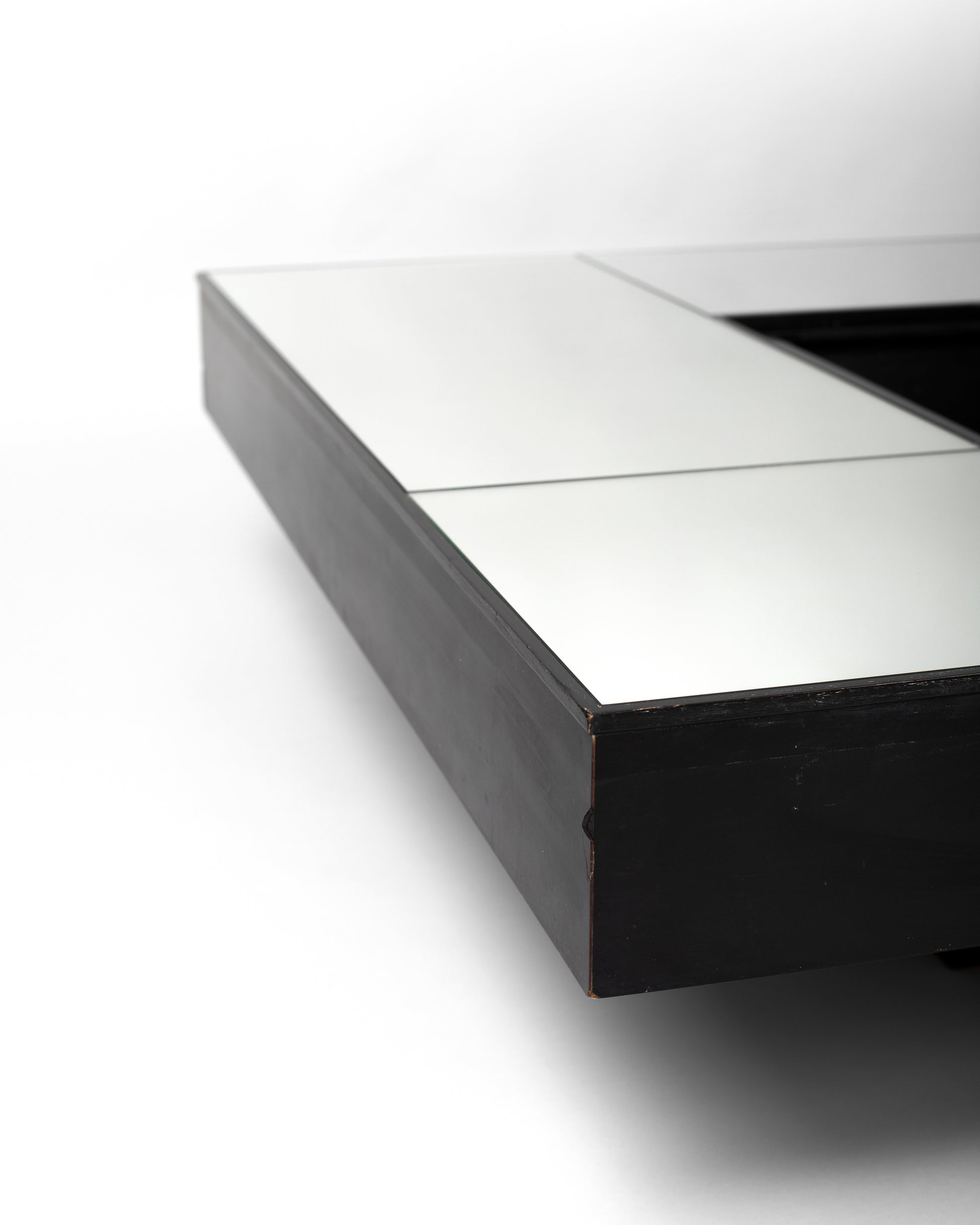 Mirrored coffee table from the 1970s, crafted in Italy with a black wood base and a reflective mirrored surface, showcasing a sculptural, modernist design inspired by Italian elegance and precision.