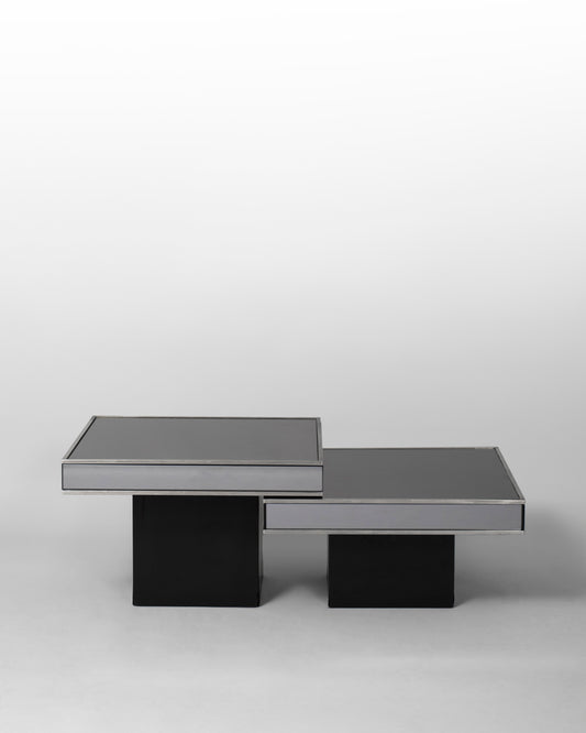 Pair of nesting tables designed by Willy Rizzo for Cidue in the 1970s, featuring chromed metal frames and black mirrored glass surfaces, blending Italian modernism with sculptural elegance.